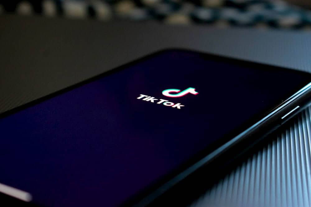 Smartphone lays on a table with the tikTok app enabled.